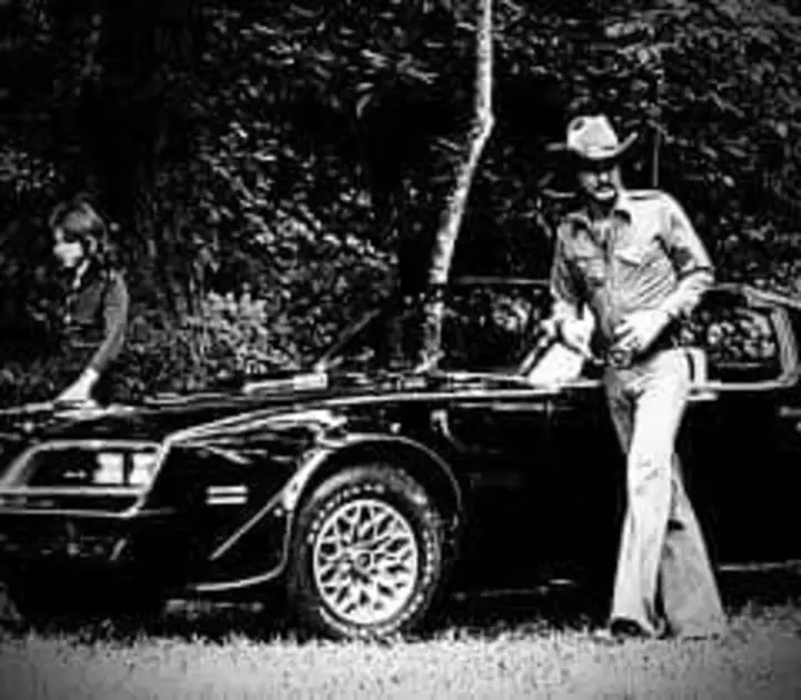 Smokey and the Bandit movie behind the scenes pic with Burt Reynolds and Sally Field getting out of Trans Am.