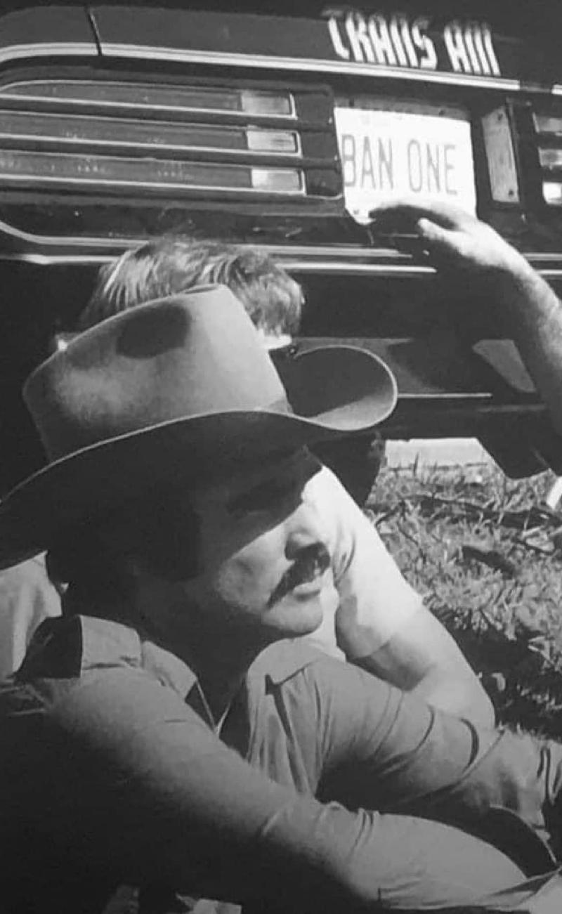Smokey and the Bandit movie behind the scenes - Burt Reynolds sitting next to one of 3 Trans Ams used in movie.