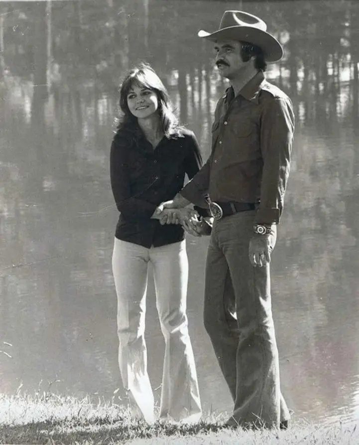 Smokey and the Bandit movie behind the scenes pic with Burt Reynolds and Sally Field holding hands.