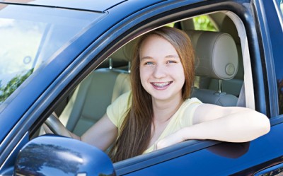 Excited teenate female driver sitting in vehicle