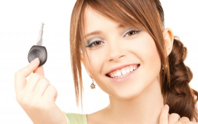 Excited teenage female holding vehicle key and ready to drive